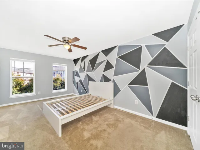 an empty room with windows and ceiling fan
