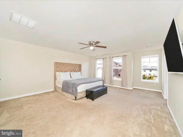 a spacious bedroom with a bed and a flat screen tv