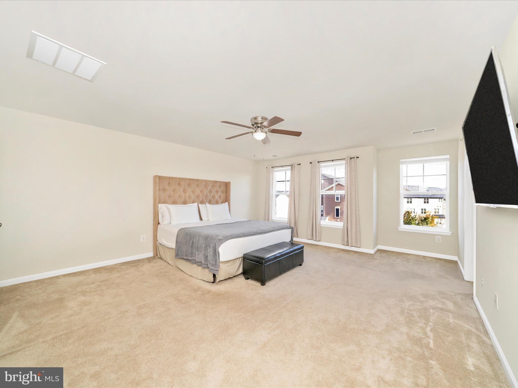 5880 Imperial Drive Frederick, MD 21703 - Photo 39 of 54 a spacious bedroom with a bed and a flat screen tv