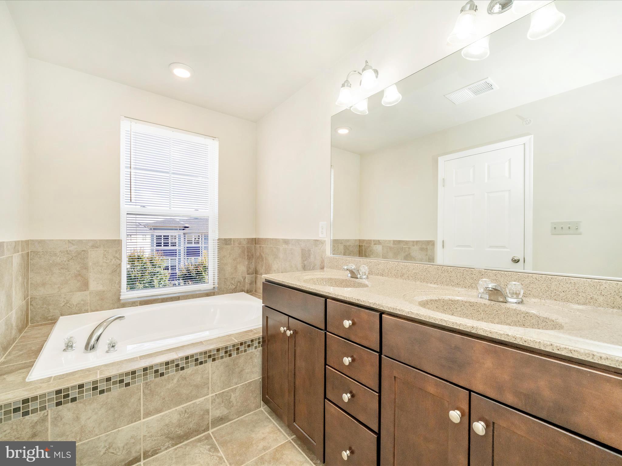 5880 Imperial Drive Frederick, MD 21703 - Photo 44 of 54 a spacious bathroom with a granite countertop tub sink shower and mirror