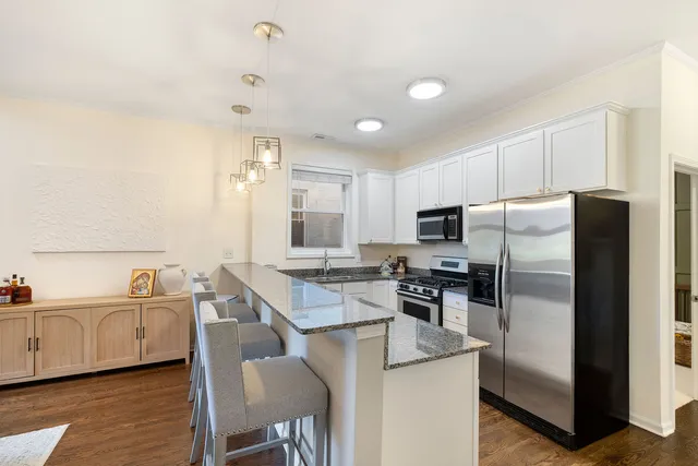 a kitchen that has a lot of cabinets a sink and appliances