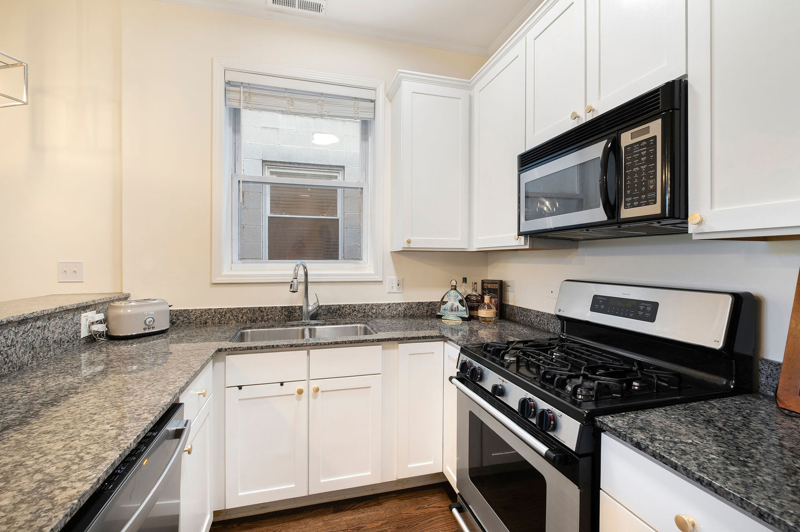 1529 West Montana Street, Unit 2 Chicago, IL 60614 - Photo 14 of 32 a kitchen with granite countertop a sink stove and microwave