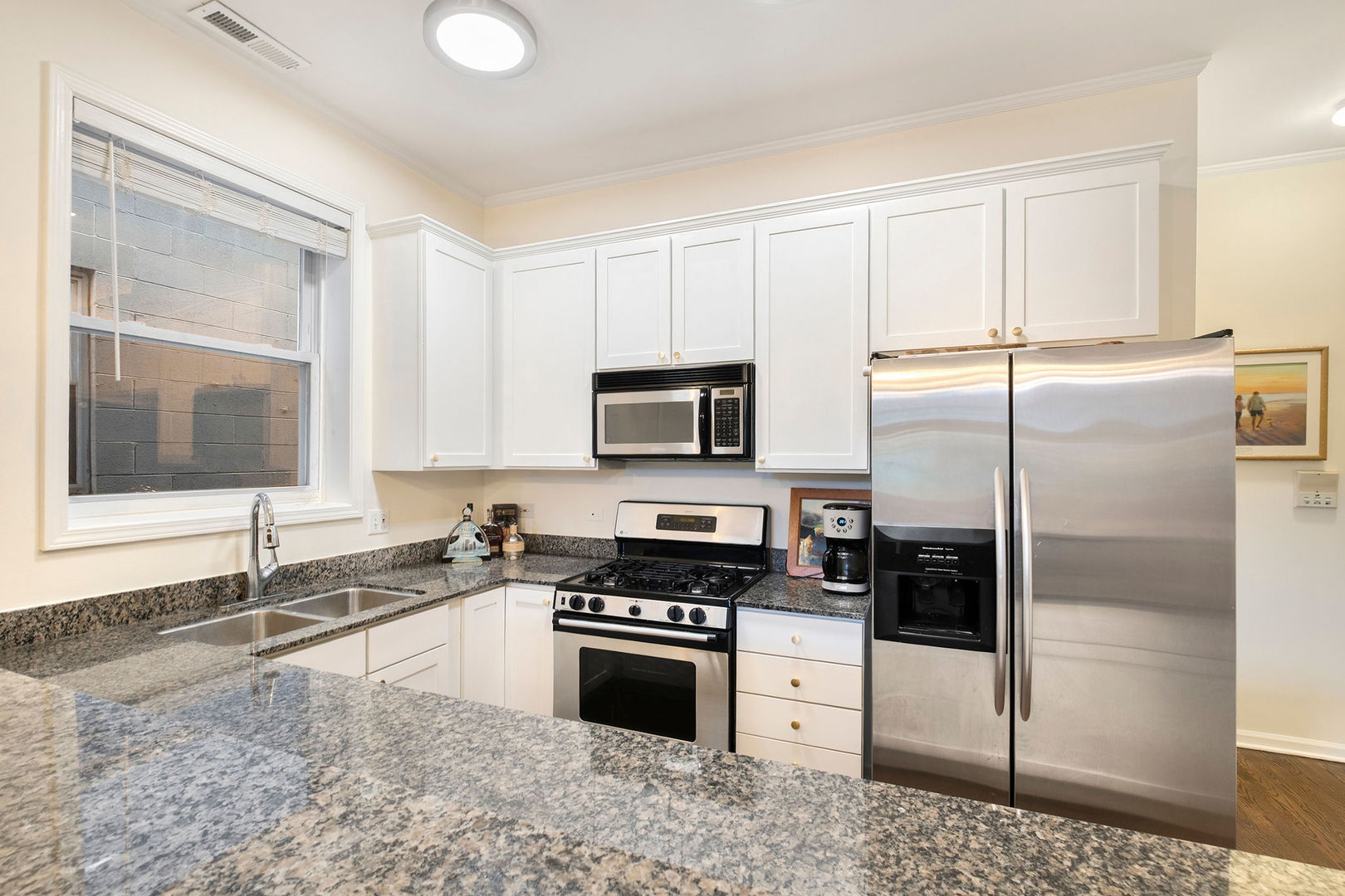1529 West Montana Street, Unit 2 Chicago, IL 60614 - Photo 16 of 32 a kitchen with granite countertop a refrigerator stove and microwave