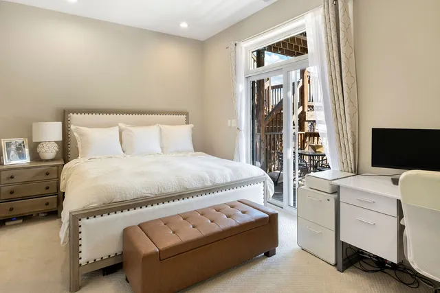 a bedroom with a bed and a flat tv screen on dresser