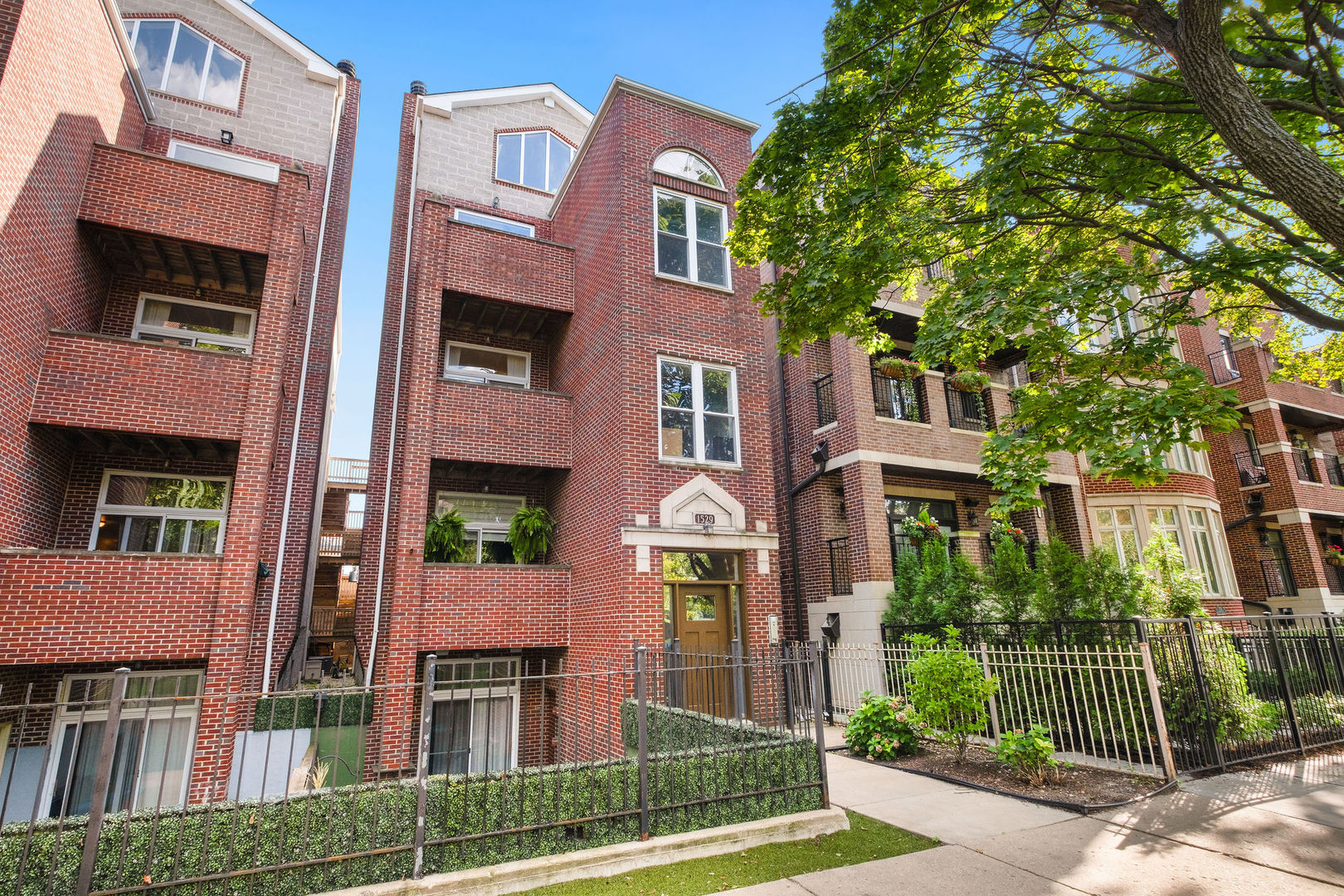 1529 West Montana Street, Unit 2 Chicago, IL 60614 - Photo 2 of 32 a front view of a multi story residential apartment building with a yard and potted plants
