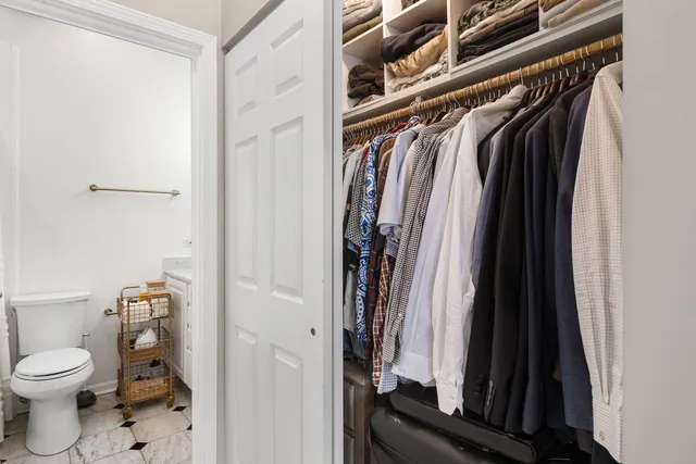 a view of walk in closet with clothes and shoes