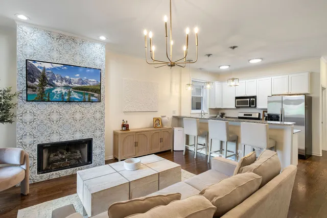 a living room with furniture a fireplace and kitchen view