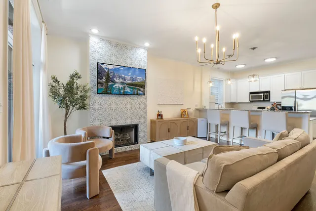 a living room with furniture a fireplace and a chandelier