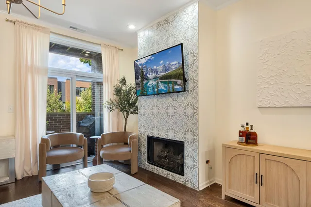 a living room with furniture a flat screen tv and a fireplace