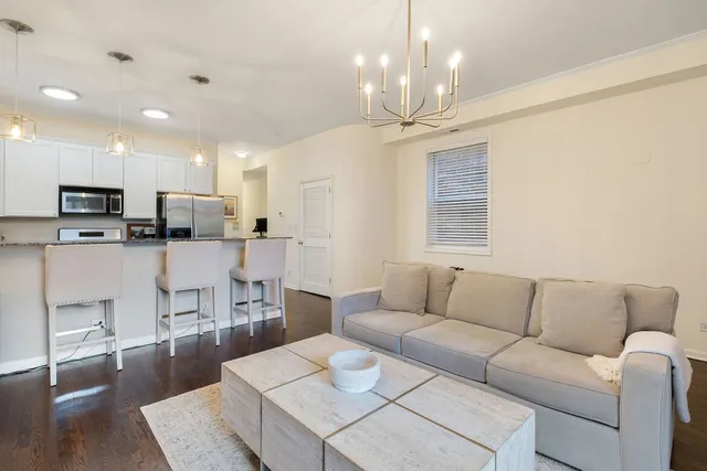 a living room with furniture kitchen and a chandelier