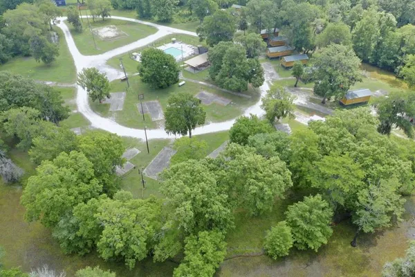an aerial view of a residential houses with trees and grass