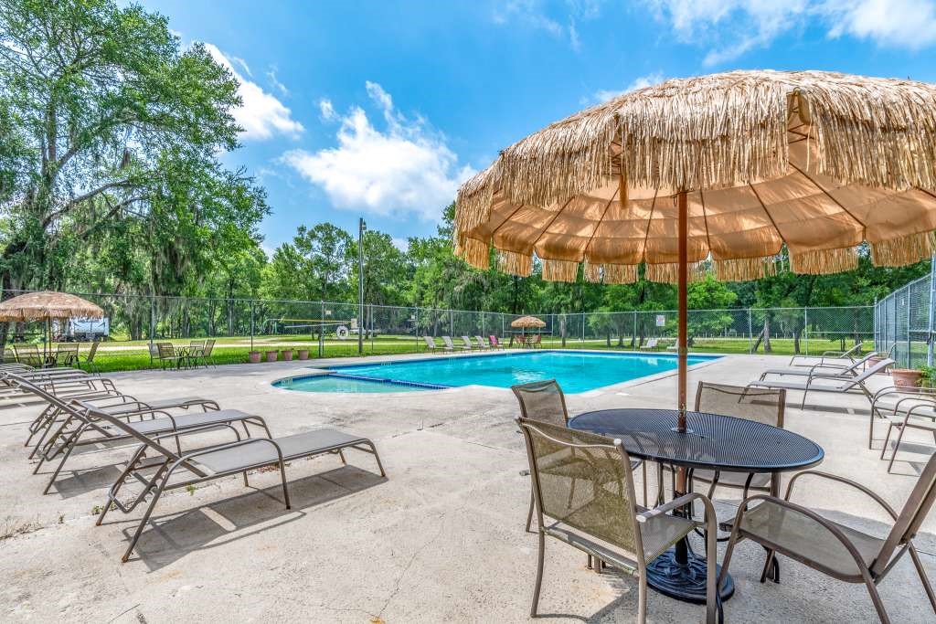 129 Shoreline Drive Cleveland, TX 77327 - Photo 14 of 22 a view of a swimming pool with a table and chairs under an umbrella