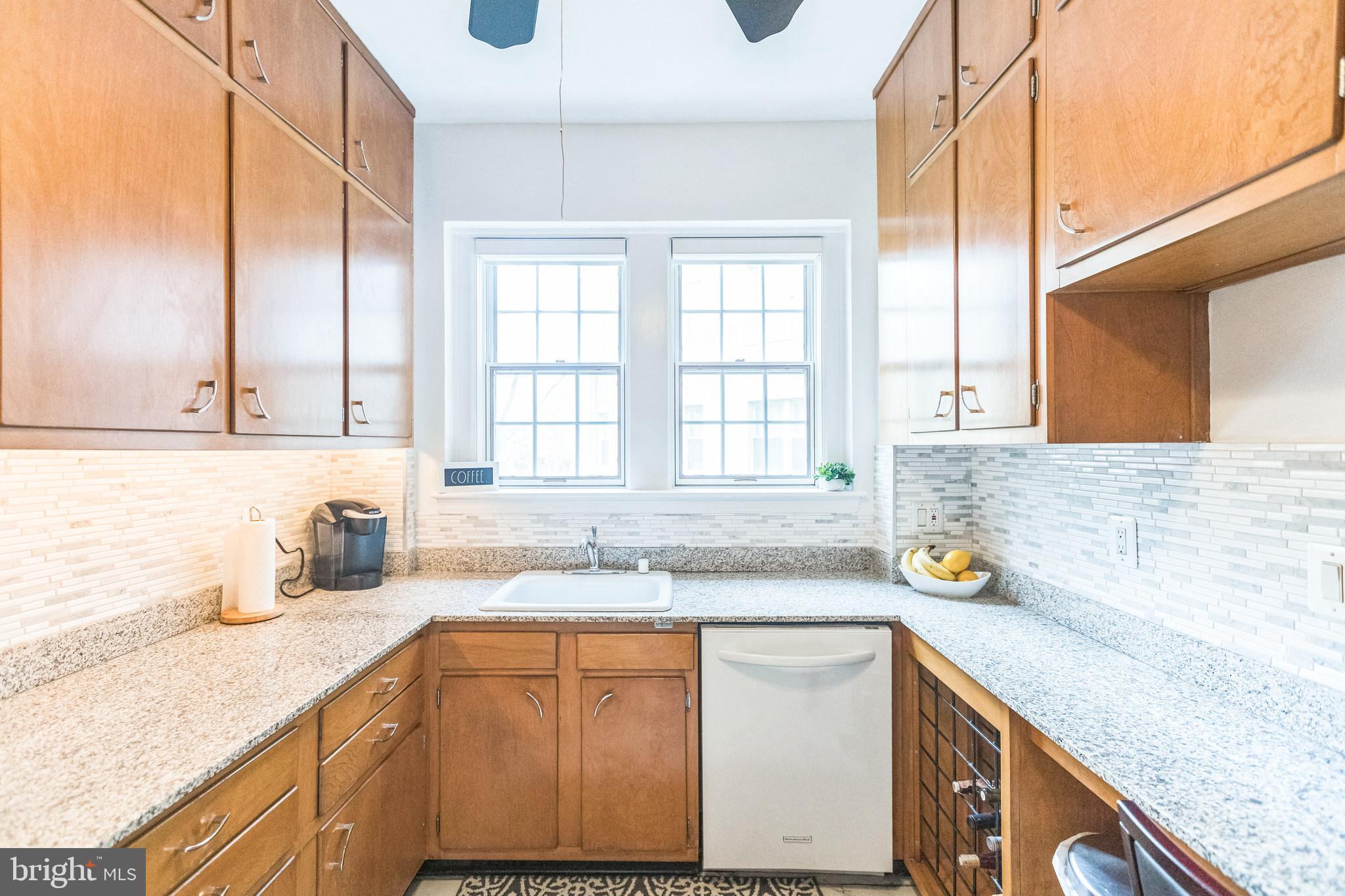 2737 Devonshire Place Northwest, Unit 7 Washington, DC 20008 - Photo 17 of 36 a kitchen with stainless steel appliances granite countertop a sink a stove and a granite counter tops with wooden floors