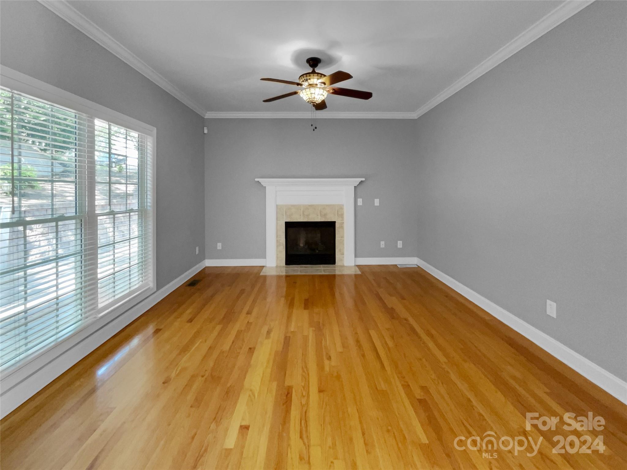 12047 Spinnaker Drive Fort Mill, SC 29708 - Photo 3 of 17 a view of a room with wooden floor and a ceiling fan