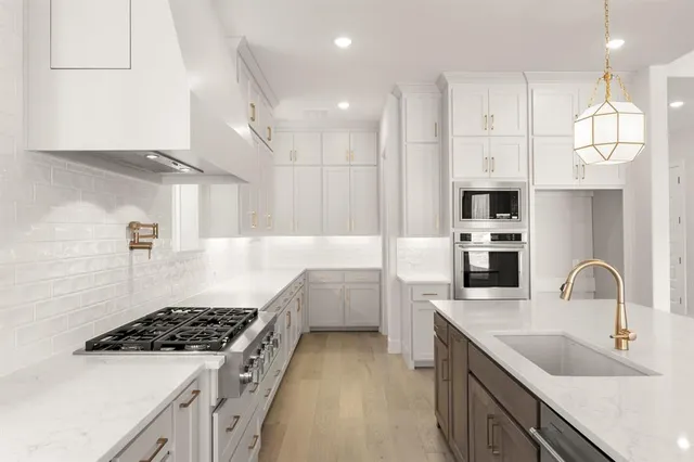 a kitchen with kitchen island white cabinets a sink stove and refrigerator
