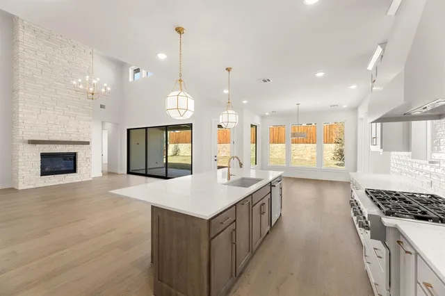 a kitchen with kitchen island a sink stainless steel appliances and a counter top space