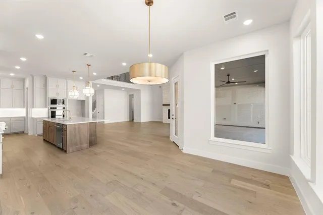 a view of a kitchen with a refrigerator a microwave and a sink