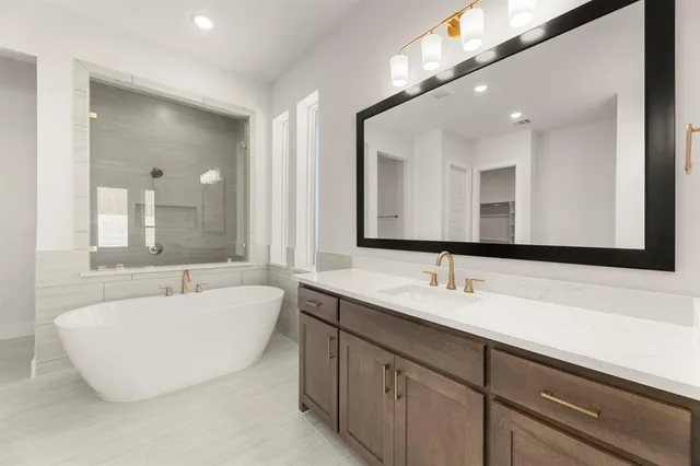a bathroom with a tub sink and mirror