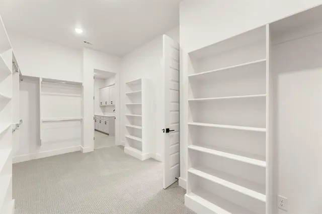 a view of walk in closet with empty racks