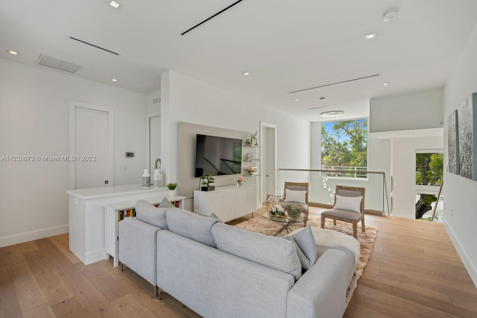 4610 Alton Road Miami Beach, FL 33140 - Photo 18 of 38 a living room with furniture and a flat screen tv
