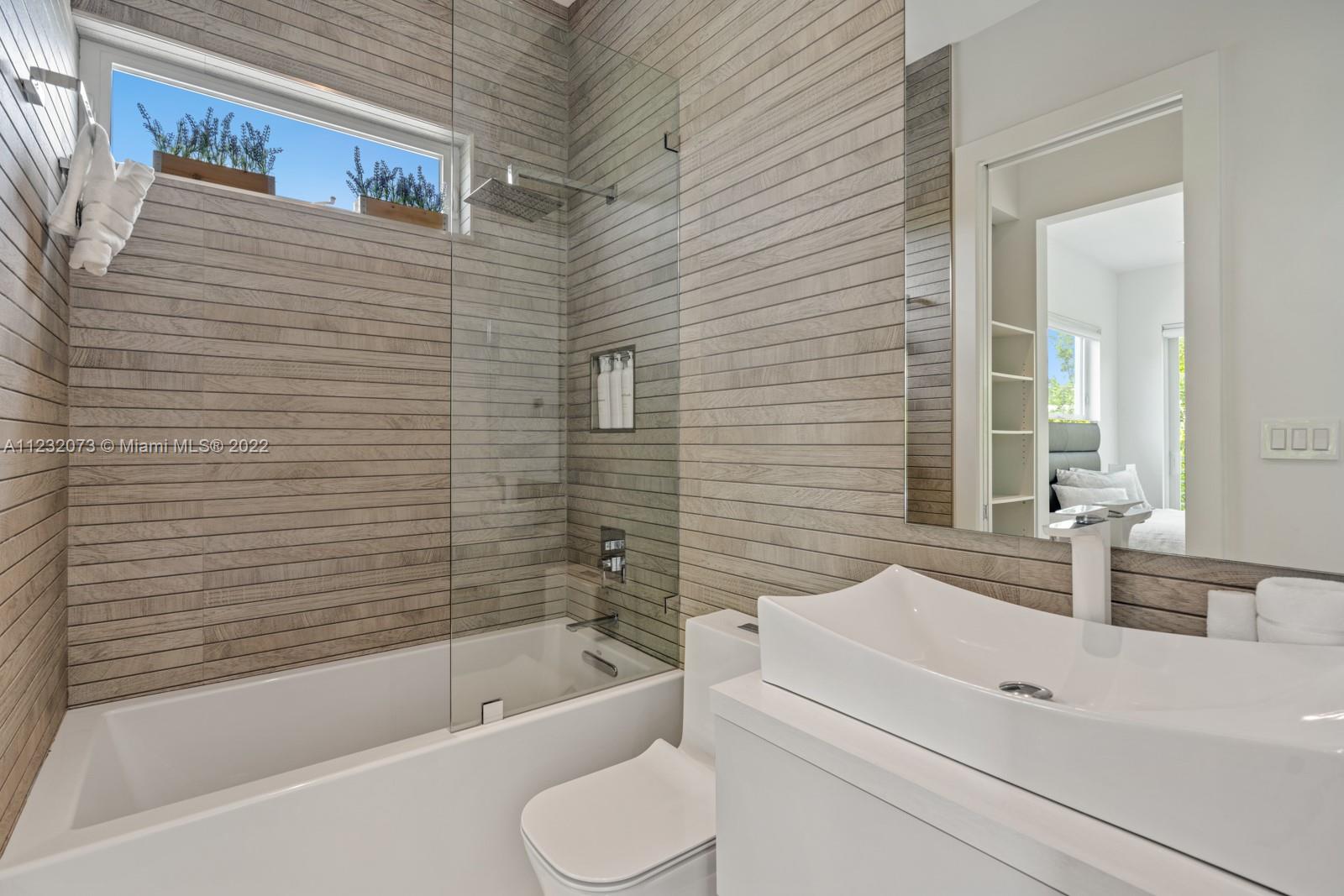 4610 Alton Road Miami Beach, FL 33140 - Photo 21 of 38 a bathroom with a sink a toilet and bathtub
