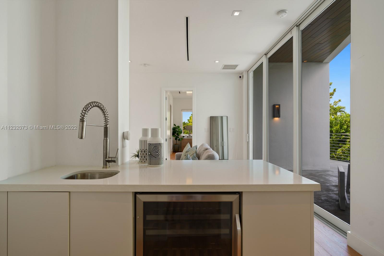 4610 Alton Road Miami Beach, FL 33140 - Photo 25 of 38 a kitchen with a sink and a refrigerator