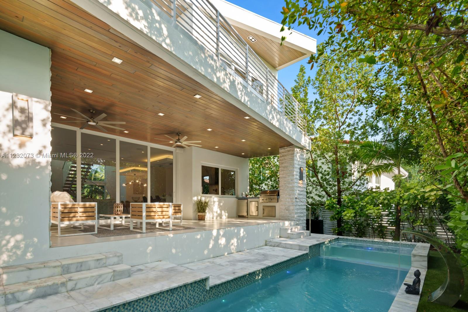 4610 Alton Road Miami Beach, FL 33140 - Photo 31 of 38 a view of a patio with table and chairs with wooden floor and fence