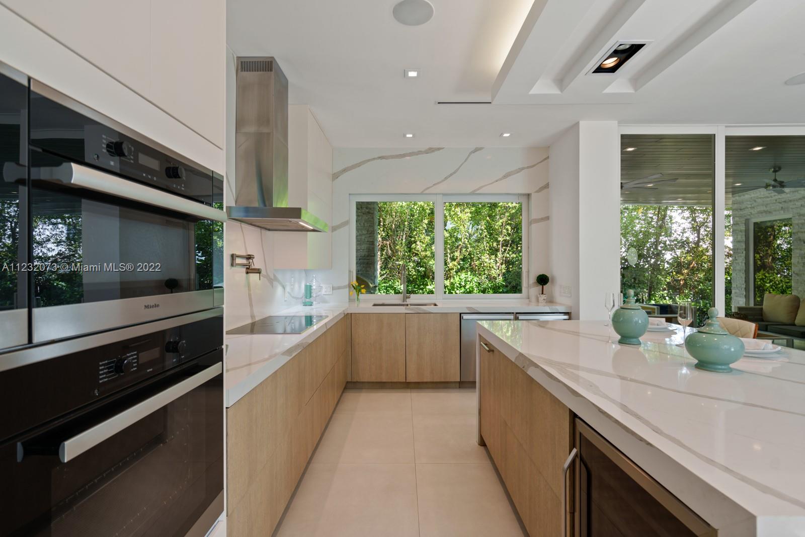 4610 Alton Road Miami Beach, FL 33140 - Photo 8 of 38 a large white kitchen with a large window