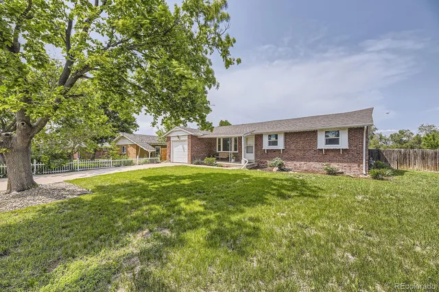 a view of a house with backyard and a tree