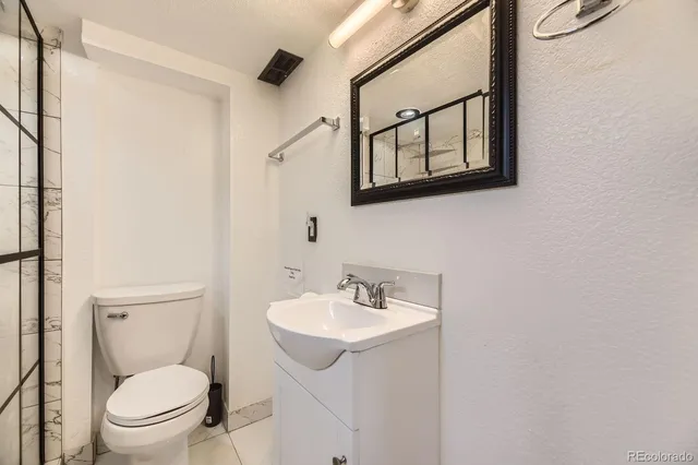 a bathroom with a toilet a sink and mirror