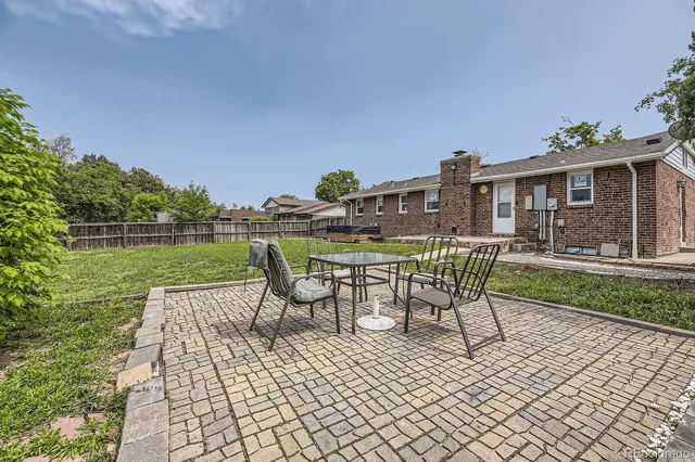a view of a swimming pool with a patio and a yard