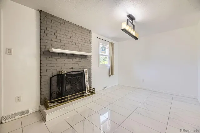 a view of a livingroom with a fireplace and window