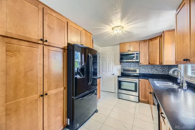 a kitchen with stainless steel appliances a refrigerator sink and cabinets