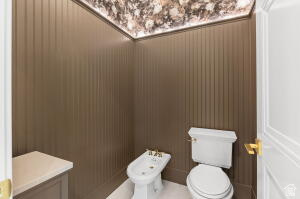 1141 East Lost Ridge Drive Washington, UT 84780 - Photo 68 of 108 Bathroom featuring vertical paneling, a marble-effect ceiling, and a white toilet