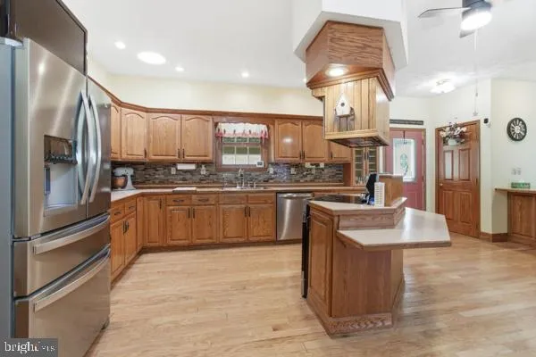 a kitchen with stainless steel appliances granite countertop a sink a stove and a refrigerator