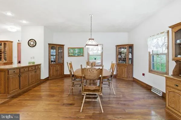 a dining room with furniture a chandelier and wooden floor