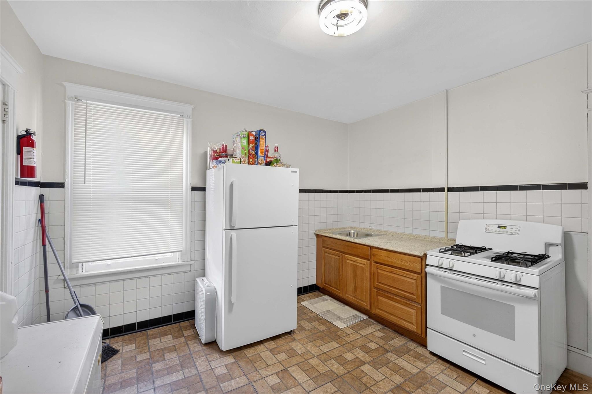 60 Lent Street Poughkeepsie, NY 12601 - Photo 8 of 16 a kitchen with a refrigerator and white cabinets