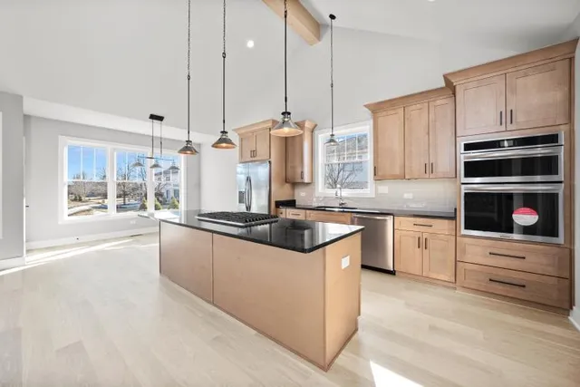 a kitchen with stainless steel appliances granite countertop a stove a sink and a microwave