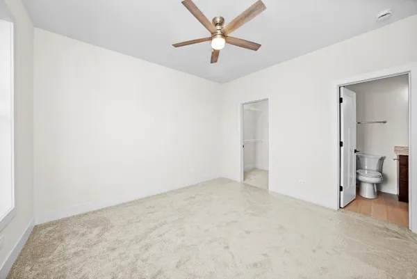 an empty room with fan and entrance