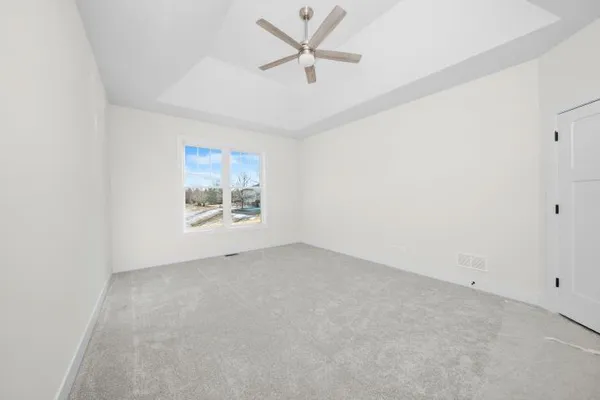 an empty room with a window and a ceiling fan