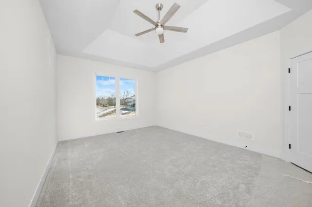 an empty room with a window and a ceiling fan