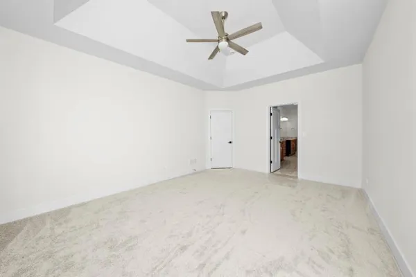 an empty room with a ceiling fan and a window