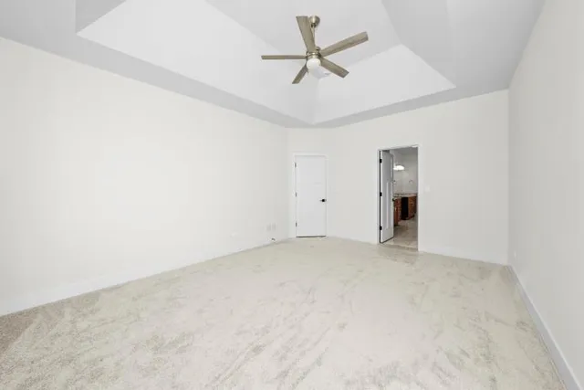 an empty room with a ceiling fan and a window