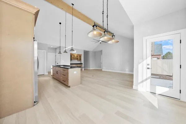 a view of a kitchen with furniture and stainless steel appliances