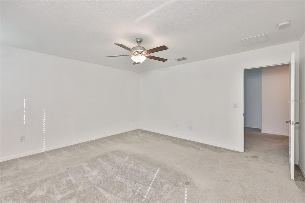 9913 Jackfruit Court Riverview, FL 33578 - Photo 33 of 57 an empty room with a chandelier fan and windows