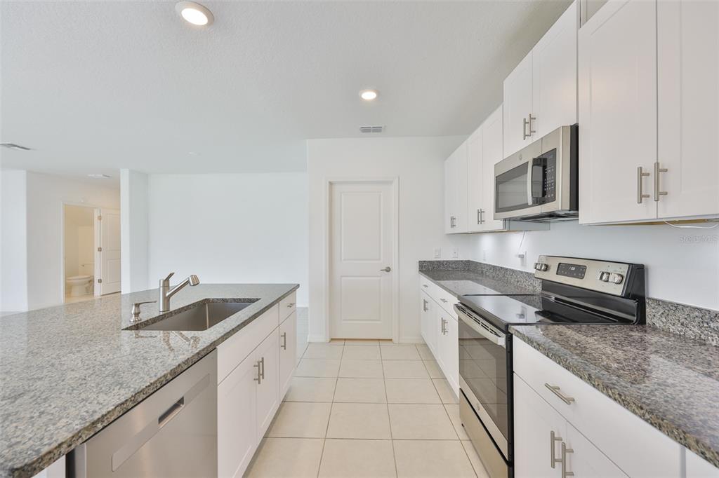 9913 Jackfruit Court Riverview, FL 33578 - Photo 8 of 57 a kitchen with granite countertop a sink and cabinets
