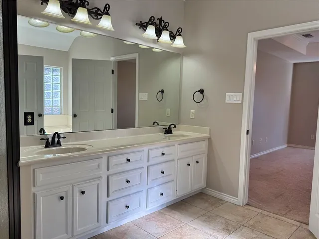 a bathroom with double sink and a mirror