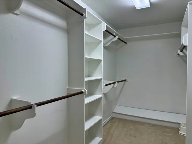 a view of walk in closet with empty racks