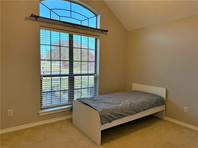 a bed sitting in a bedroom next to a window