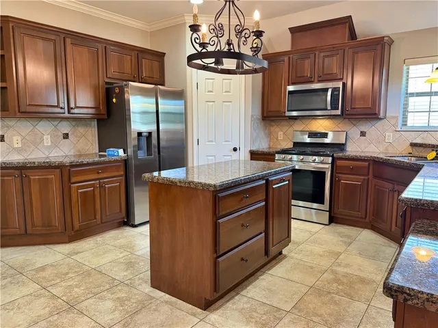 a kitchen with stainless steel appliances granite countertop a stove microwave and refrigerator
